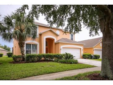 Two-story house with attached garage and manicured lawn at 2718 Lido Key Dr, Kissimmee, FL 34747