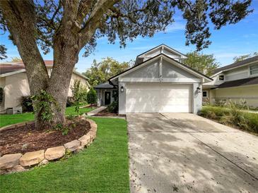 Exterior view of a charming house with a large tree and landscaping at 379 Cidermill Pl, Lake Mary, FL 32746