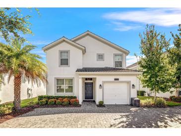 Two-story house with a white exterior and a two car garage at 4782 Kings Castle Cir, Kissimmee, FL 34746