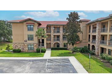 Multi-story building with stone accents and lush landscaping at 909 Charo Pkwy # 1021, Davenport, FL 33897