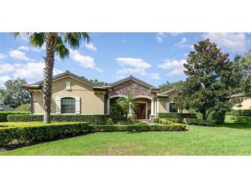 One-story home with stone accents and lush landscaping at 25822 Feather Ridge Ln, Sorrento, FL 32776