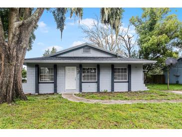 Newly renovated home with gray exterior, landscaped lawn, and walkway at 771 Rich Dr, Oviedo, FL 32765