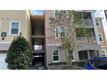 Three-story condo building with parking and trees at 3384 Corona Village Way # 108, Orlando, FL 32835