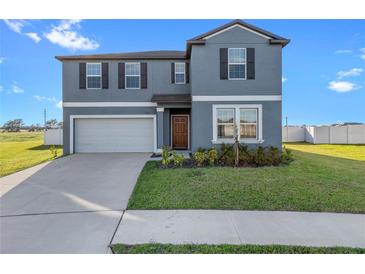 Two-story house with gray siding and landscaping at 3519 Lounging Wren Ln, Bartow, FL 33830