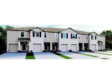 Modern townhome style with attached garages, neutral exterior, and well-manicured lawns at 2224 Tongass Bnd, Davenport, FL 33837