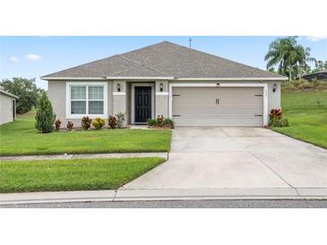 Single-story house with a two-car garage and well-maintained lawn at 205 Bella Verano Way, Davenport, FL 33897
