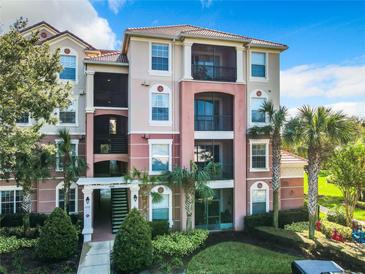 Three-story condo building with balconies and landscaping at 8298 Portofino Dr # 202, Davenport, FL 33896