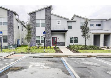 Modern two-story home with red door and landscaping at 690 Pebble Beach Dr, Davenport, FL 33896