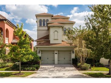 A stunning three-story home with a two-car garage, landscaped yard and stucco exterior at 1169 Castle Pines Ct, Reunion, FL 34747