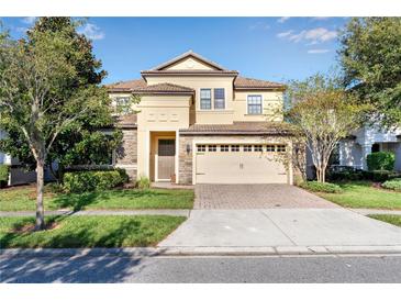 Two-story house with stone accents and a two-car garage at 1406 Moon Valley Dr, Davenport, FL 33896