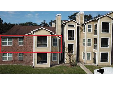 Brick and siding two-story condo exterior at 5600 Devonbriar Way # N202, Orlando, FL 32822