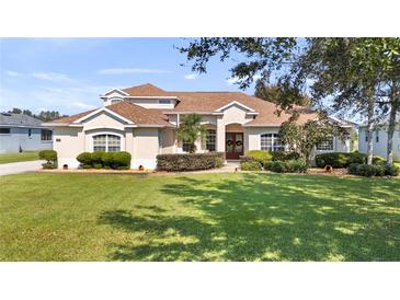 Two story house with a large lawn and mature trees at 7351 Spring Mountain Ln, Yalaha, FL 34797