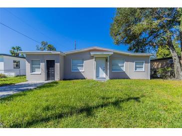 Ranch-style home with a well-maintained lawn at 1300 Mercy Dr, Orlando, FL 32808