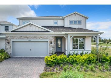 Two-story home with gray siding, stone accents, and a covered entryway at 10411 Park Estate Avenue, Orlando, FL 32836