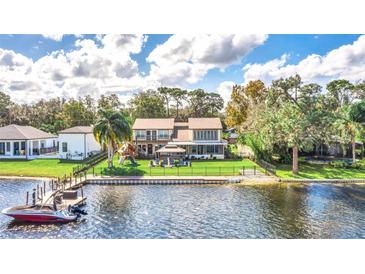 Aerial view showcasing a beautiful lakefront home with a backyard and dock at 621 E Wildmere Ave, Longwood, FL 32750