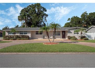 Ranch-style home with circular driveway, landscaping, and mature trees at 2891 Naples Dr, Winter Park, FL 32789