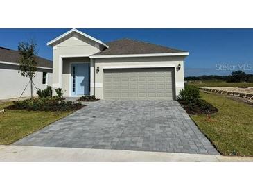 One-story house with light gray siding and a two-car garage at 3112 Windswept Way, Wildwood, FL 34785