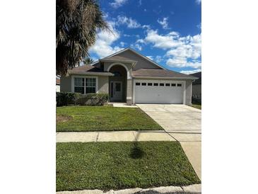 House exterior with two-car garage and landscaping at 2521 Oneida Loop, Kissimmee, FL 34747