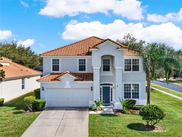 Two-story house with tile roof, gray siding, and a two-car garage at 2615 Archfeld Blvd, Kissimmee, FL 34747