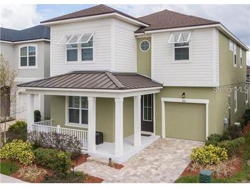 Two-story house with a green exterior, brown roof, and a porch at 1861 Sawyer Palm Pl, Kissimmee, FL 34747