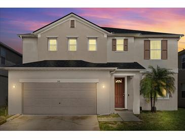 Two-story house with a two car garage and front yard at 348 Sand Ridge Dr, Davenport, FL 33896