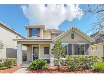 Two-story house with a front porch, stone accents, and landscaping at 8795 Ribault Ave, Orlando, FL 32832