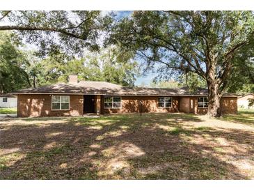 Ranch style brick home with mature oak trees and a spacious yard at 7129 Oakwind Dr, Orlando, FL 32818