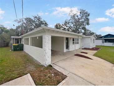 House exterior showcasing a covered entryway and landscaping at 908 Perkins St, Leesburg, FL 34748