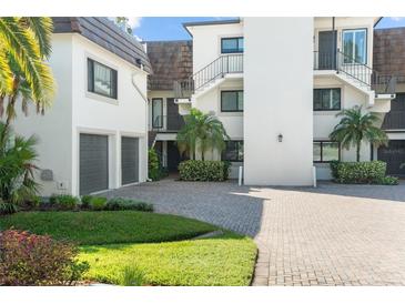 Exterior view of condo building with attached garage and paved driveway at 8984 Houston Pl # 103, Orlando, FL 32819