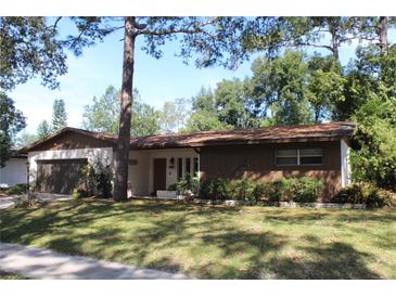 Ranch style home with carport, mature landscaping, and a spacious yard at 4663 Montauk St, Orlando, FL 32808