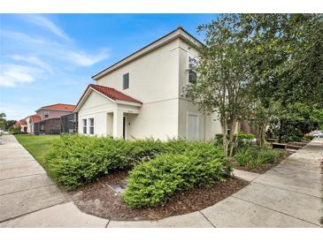 Two-story house with light-colored exterior, landscaping, and sidewalk at 4562 Baleno Ln, Kissimmee, FL 34746