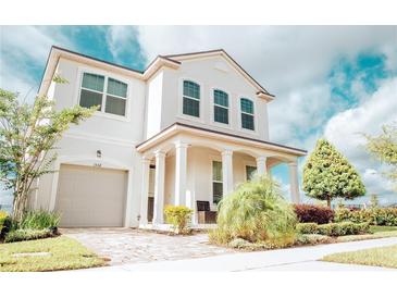 Two-story house with a light-colored facade, a large garage, and landscaping at 1532 Nassau Point Trl, Kissimmee, FL 34747