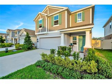 Two-story house with gray siding, green shutters, and landscaping at 1093 Berry Ln, Davenport, FL 33837