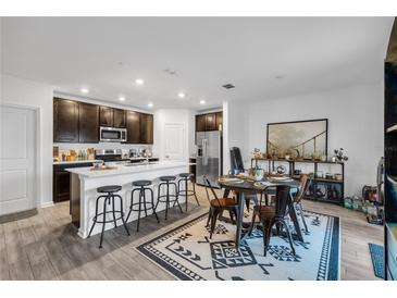 Modern kitchen with island, stainless steel appliances, and dark cabinets at 1093 Berry Ln, Davenport, FL 33837