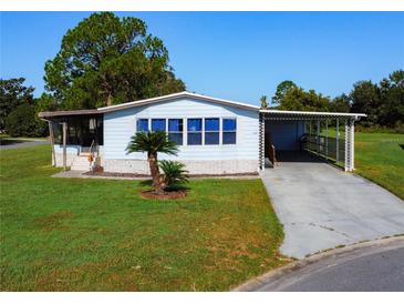 Single-wide manufactured home with carport and landscaped yard at 202 Ellsworth Ct, Kissimmee, FL 34758