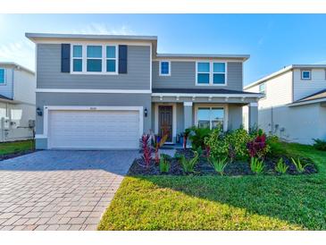 Two story house with gray siding, landscaping, and a double garage at 4009 Winding Meadows St, Apopka, FL 32712