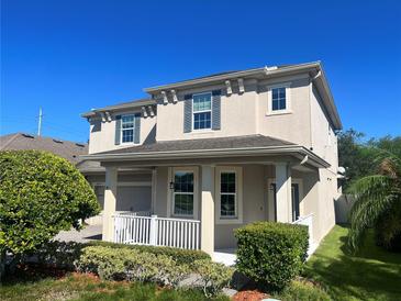 Two-story house with a gray exterior, white porch, and landscaping at 8077 Pleasant Pine Cir, Winter Park, FL 32792