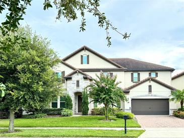 Two-story house with stone accents and a three-car garage at 8426 Morehouse Dr, Orlando, FL 32836