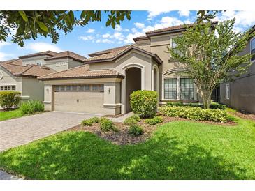 Two-story house with a three-car garage and manicured lawn at 1473 Moon Valley Dr, Davenport, FL 33896
