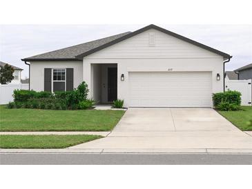 White one-story house with dark gray accents and two-car garage at 1637 Hill Park Dr, Deltona, FL 32725