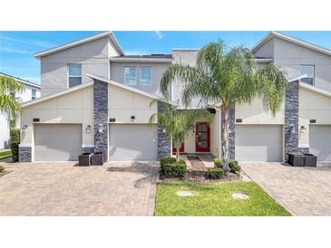 Modern three-unit townhome building with attached garages at 543 Ocean Course Ave, Davenport, FL 33896