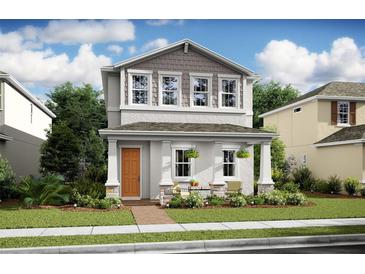 Two-story home with gray and beige siding, orange door and front porch at 12614 Clear Sapphire Dr # 137, Winter Garden, FL 34787