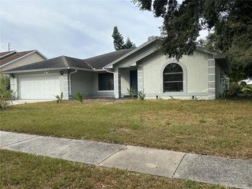 Single-story house with a two-car garage and well-maintained lawn at 1544 Dess Dr, Orlando, FL 32818