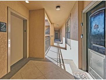 Building hallway with elevator and apartment access at 912 Charo Pkwy # 223, Davenport, FL 33897