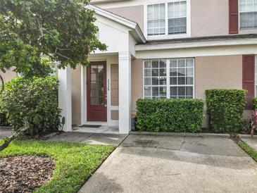 Townhouse exterior with landscaping and a red door at 2338 Silver Palm Dr, Kissimmee, FL 34747