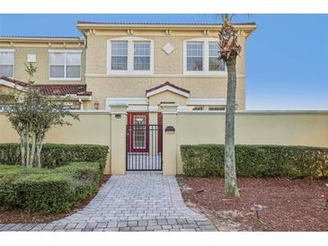 Two-story townhouse with red door and paved walkway at 2960 Bella Vista Dr, Davenport, FL 33897