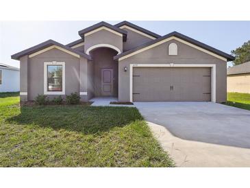 Newly constructed home with two-car garage and well-manicured lawn at 279 Fig Ct, Poinciana, FL 34759