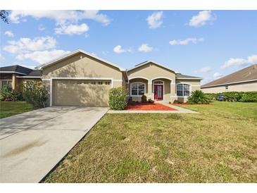 One-story home with two-car garage and red front door at 6311 Alamanda Hills Dr, Lakeland, FL 33813
