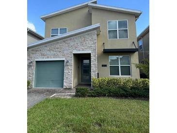 Modern two-story house with green door and stone accents at 2813 Bookmark Dr, Kissimmee, FL 34746