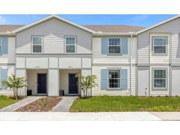 Two-story townhome with light-colored siding and a landscaped yard at 4306 Lana Ave, Davenport, FL 33897